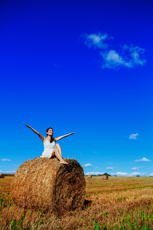 beautiful woman in the harvested  wheat field in august on a sunny dayの写真素材