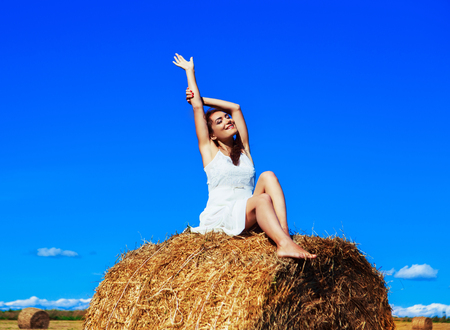 beautiful woman in the harvested  wheat field in august on a sunny dayの写真素材