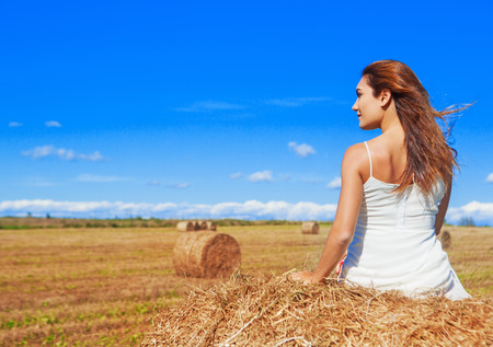 beautiful woman in the harvested  wheat field in august on a sunny dayの写真素材