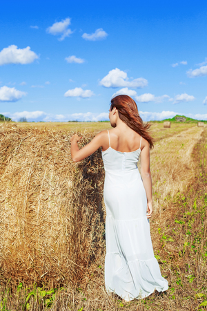 beautiful woman in the harvested  wheat field in august on a sunny dayの写真素材