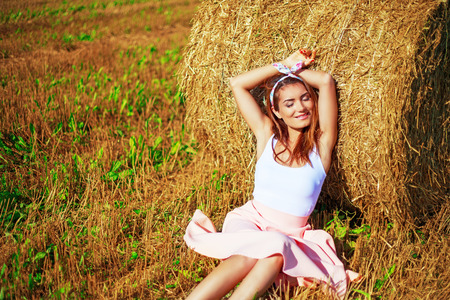 beautiful woman in the harvested  wheat field in august on a sunny dayの写真素材