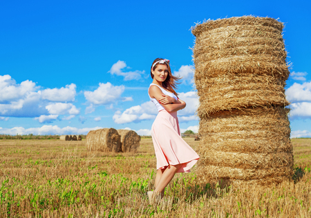 beautiful woman in the harvested  wheat field in august on a sunny dayの写真素材