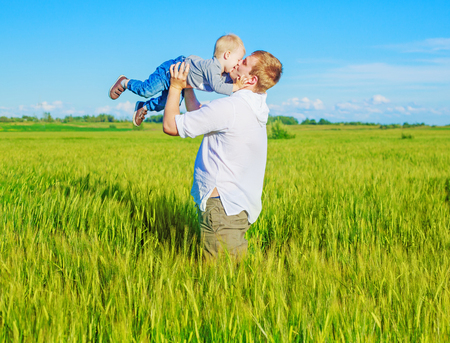 happy young parents and a son  in the wheat fieldの写真素材