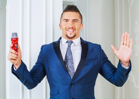 stylish man wearing a suit with a microphone in the interiorの写真素材