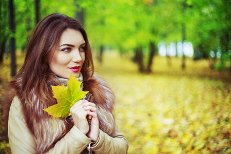 beautiful young woman   in the autumn park outdoorの写真素材