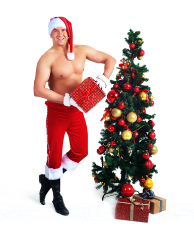 attractive muscular  young man wearing a Santa's hat with Christmas tree in the studio, isolatedの写真素材