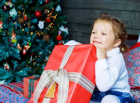 happy girl at home with Christmas tree and presentsの写真素材