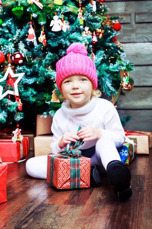 happy girl at home with Christmas presents and treeの写真素材