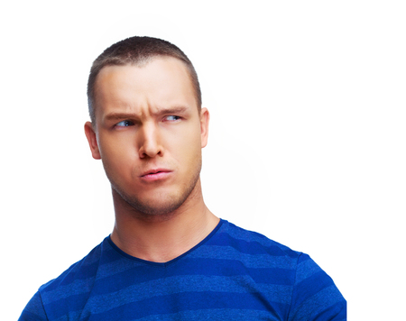 worried suspicious young man isolated against white studio backgroundの写真素材
