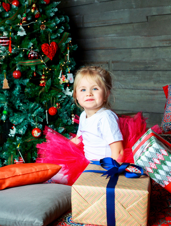 happy girl at home in bed with Christmas tree and presentsの写真素材