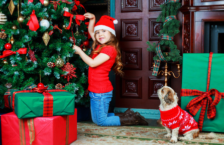 happy girl with Christmas tree and presents at homeの写真素材