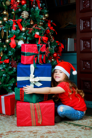 happy girl with Christmas tree and presents at homeの写真素材