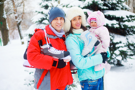 happy family with one baby goign ice-skating outdoor in the winter parkの写真素材