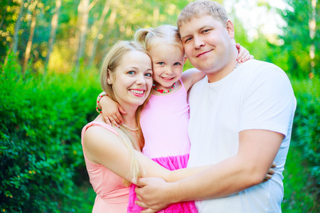 happy parents with their daughter outdoor in the summer parkの写真素材