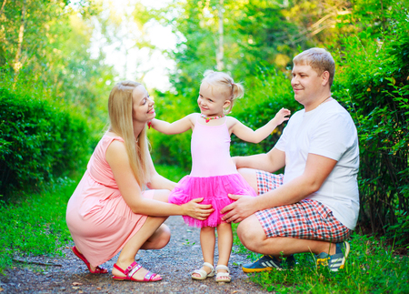 happy parents with their daughter outdoor in the summer parkの写真素材