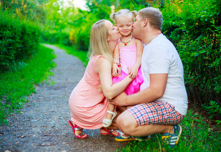 happy parents with their daughter outdoor in the summer parkの写真素材