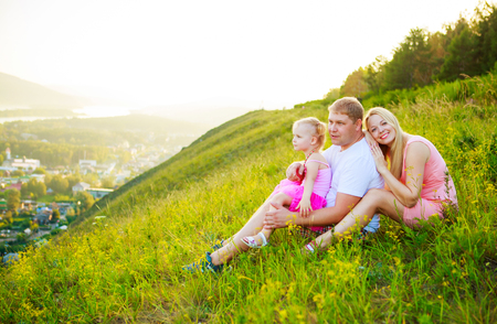 happy parents with their daughter outdoor in the summer parkの写真素材