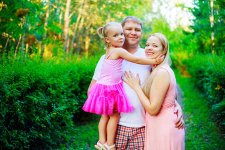 happy parents with their daughter outdoor in the summer parkの写真素材