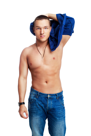 portrait of a muscular young  man taking off his shirt isolated against white backgroundの写真素材