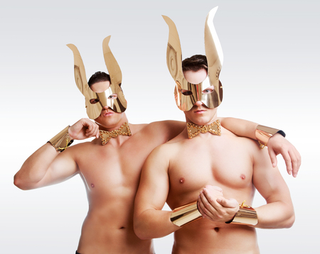 striptease dancers wearing   golden rabbit ears in the studio isolated against white backgroundの写真素材