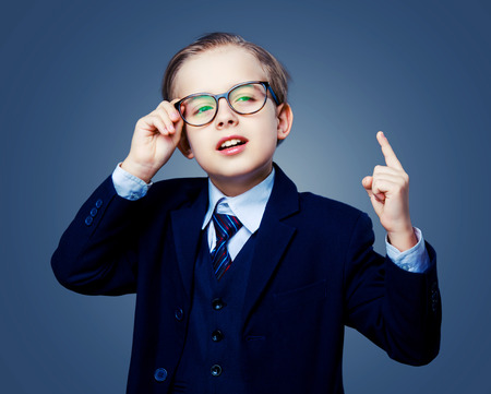 hansome boy wearing glasses and a black suit, isolated against studio backgroundの写真素材