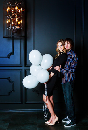 happy beautiful young couple in the   interior with white balloonsの写真素材