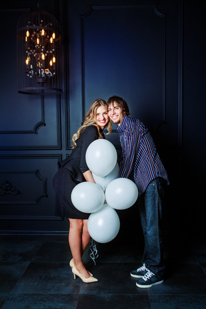 happy beautiful young couple in the   interior with white balloonsの写真素材
