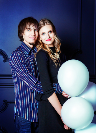 happy beautiful young couple against studio background with white balloonsの写真素材
