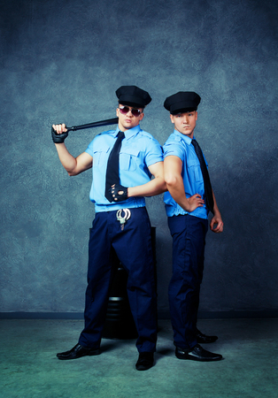 striptease dancers wearing costumes of policemen in the studioの写真素材