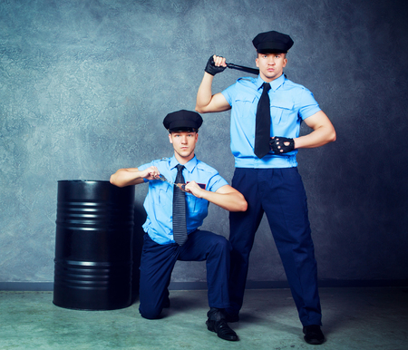striptease dancers wearing costumes of policemen in the studioの写真素材