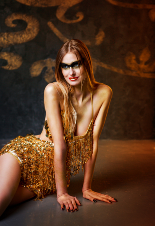 beautiful tall young blond woman with sparkling golden makeup posing  in the luxurious studio の写真素材