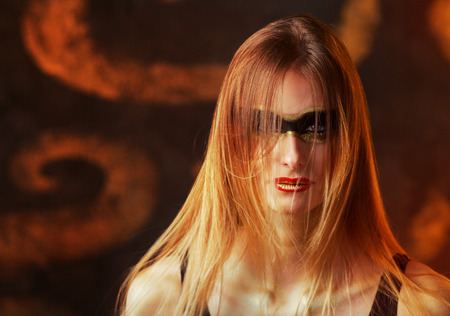 beautiful tall young blond woman with artistic golden makeup posing  in the luxurious studio の写真素材