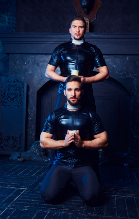 handsome striptease dancers dressed  as priests,  in the interiorの写真素材