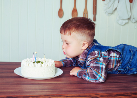 baby at home in the kitchen with a big cake with candlesの写真素材