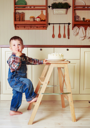 baby at home in the kitchen with a big cake with candlesの写真素材