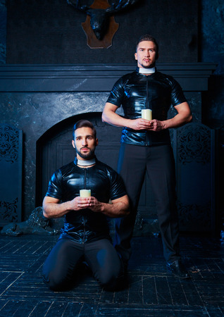 handsome striptease dancers dressed  as priests,  in the interiorの写真素材