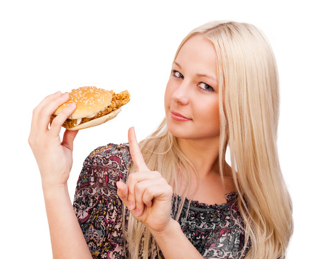 beautiful young blond woman with a burger, isolated against white backgroundの写真素材