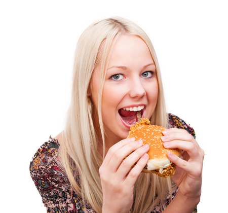 beautiful young blond woman with a burger, isolated against white backgroundの写真素材