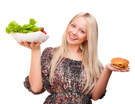 beautiful young blond woman with a burger and salad, isolated against white backgroundの写真素材