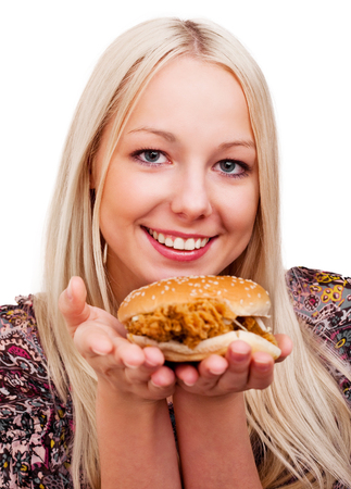 beautiful young blond woman with a burger, isolated against white backgroundの写真素材