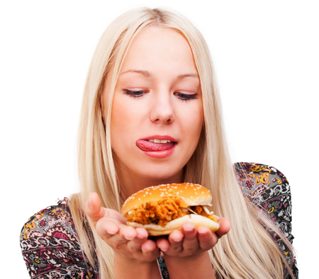 beautiful young blond woman with a burger, isolated against white backgroundの写真素材