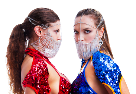 two beautiful striptease dancers wearing extravagant costumes, isolated against white backgroundの写真素材
