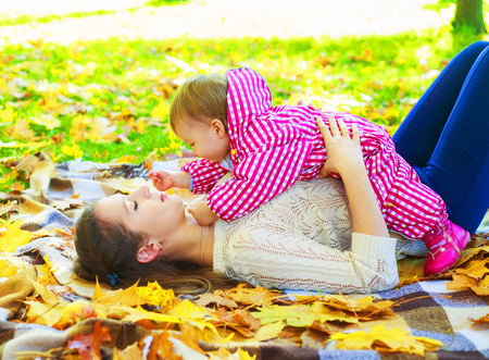 happy mother and baby spending time in the autumn parkの写真素材