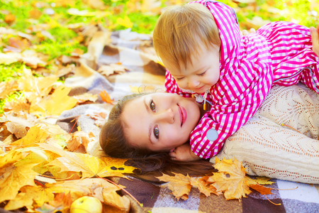 happy mother and baby spending time in the autumn parkの写真素材