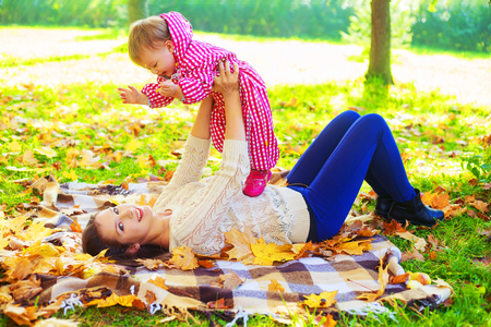 happy mother and baby spending time in the autumn parkの写真素材
