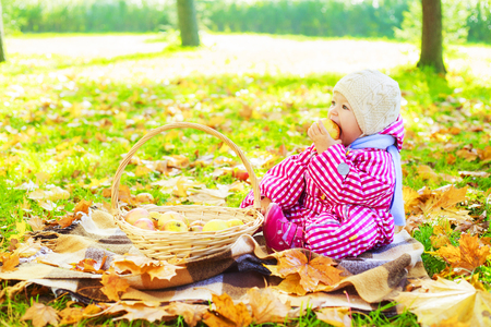 happy baby girl having a picnic in the autumn parkの写真素材