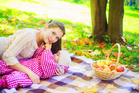 happy mother and baby having picnic in the autumn parkの写真素材