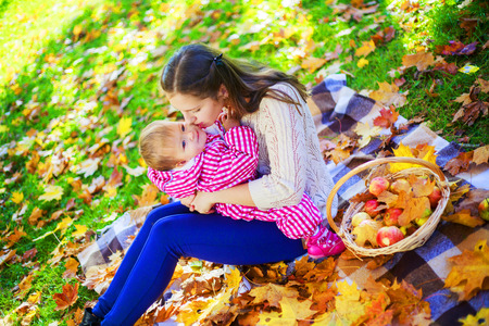 happy mother and baby having picnic in the autumn parkの写真素材