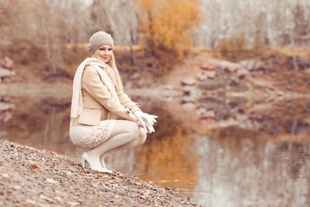 happy blond woman walking alone in the autumn parkの写真素材