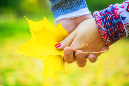 hands of a happy young couple walking and having fun in the autumn parkの写真素材
